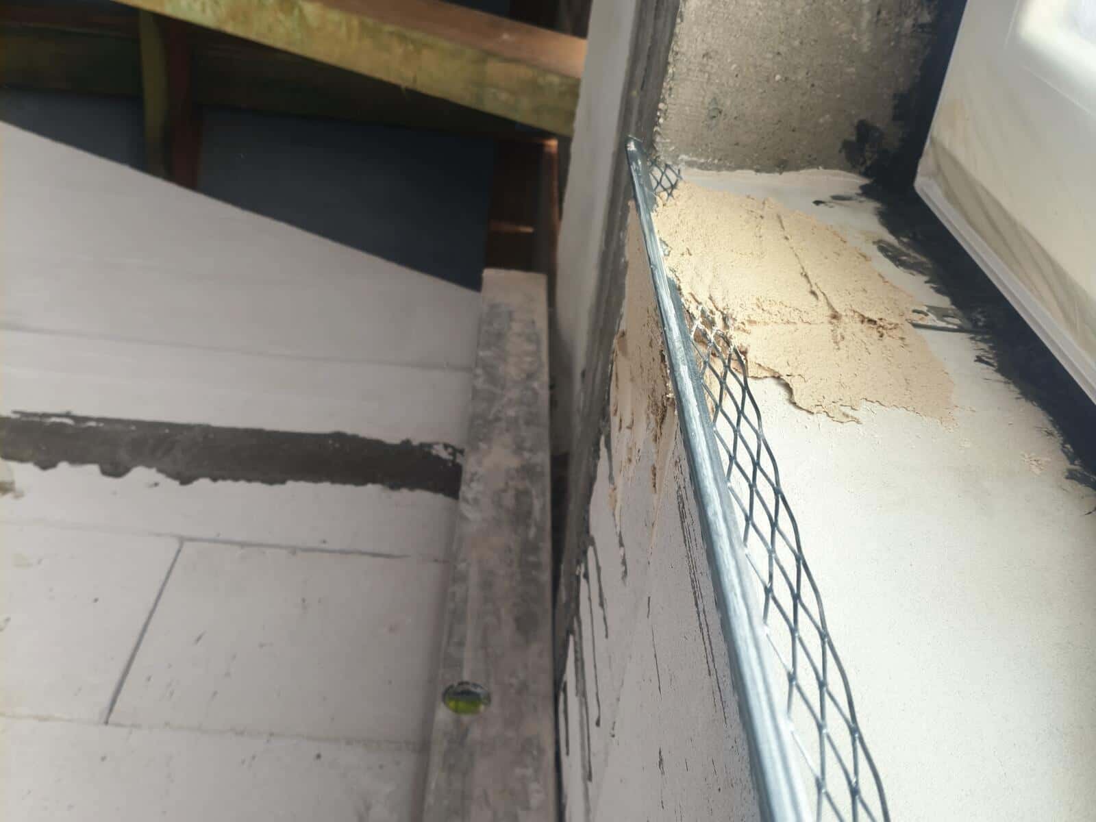 Siatka tynkarska ułożona na parapecie przed tynkowaniem